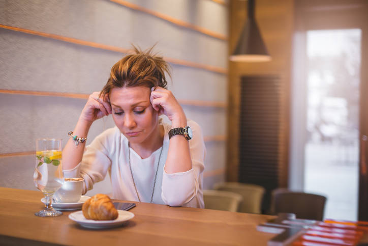 Businesswoman at coffee break having a headache